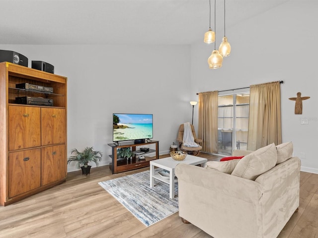 living room featuring light wood-style floors, high vaulted ceiling, and baseboards