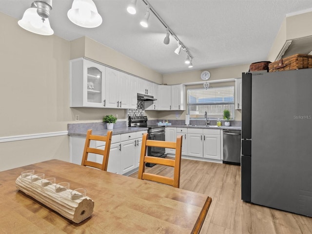 kitchen with appliances with stainless steel finishes, a sink, white cabinets, and under cabinet range hood