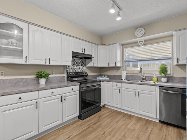 kitchen with stainless steel appliances, light wood-style flooring, white cabinets, a sink, and under cabinet range hood