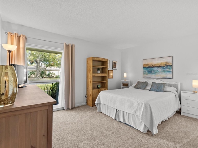 bedroom featuring a textured ceiling and light colored carpet