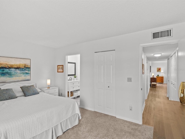 bedroom featuring light carpet, baseboards, and visible vents