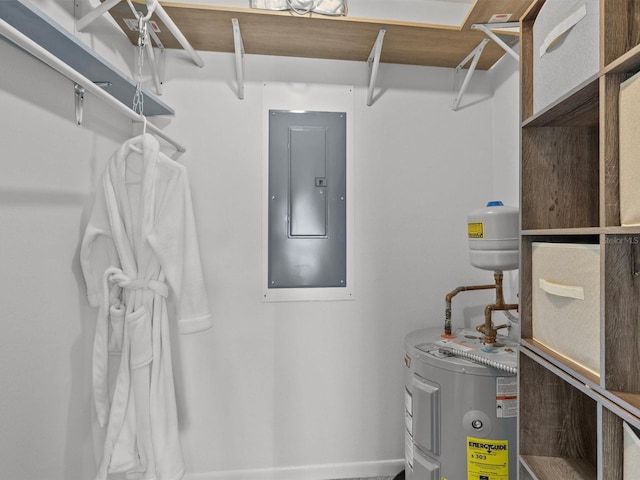 utility room with electric panel and water heater