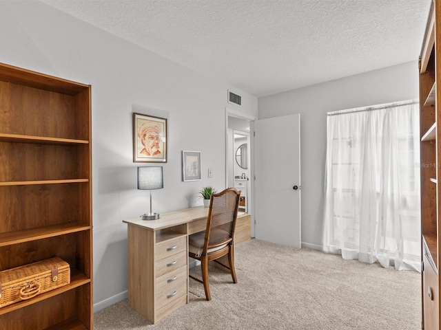 carpeted office with a textured ceiling and visible vents