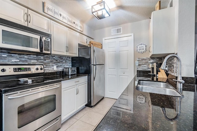 kitchen with appliances with stainless steel finishes, tasteful backsplash, white cabinetry, and sink