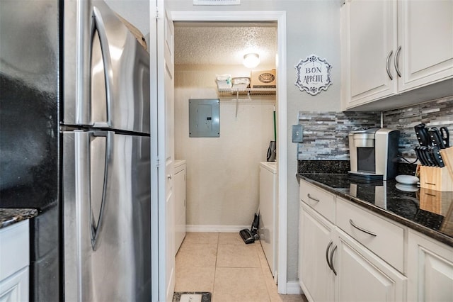 kitchen featuring a textured ceiling, electric panel, stainless steel fridge, white cabinetry, and light tile patterned flooring