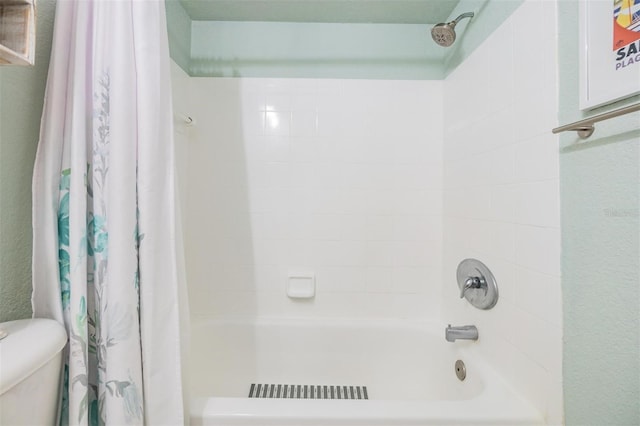 bathroom featuring toilet and shower / bathtub combination with curtain