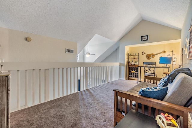 sitting room with lofted ceiling, a textured ceiling, carpet floors, and ceiling fan