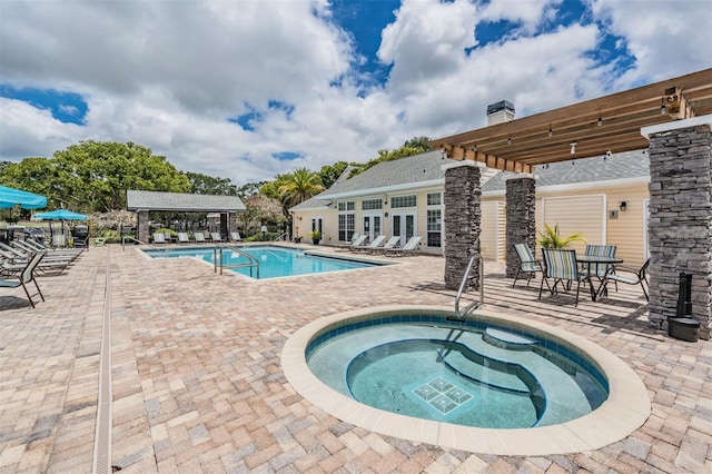 view of pool with a community hot tub, a patio area, and a pergola