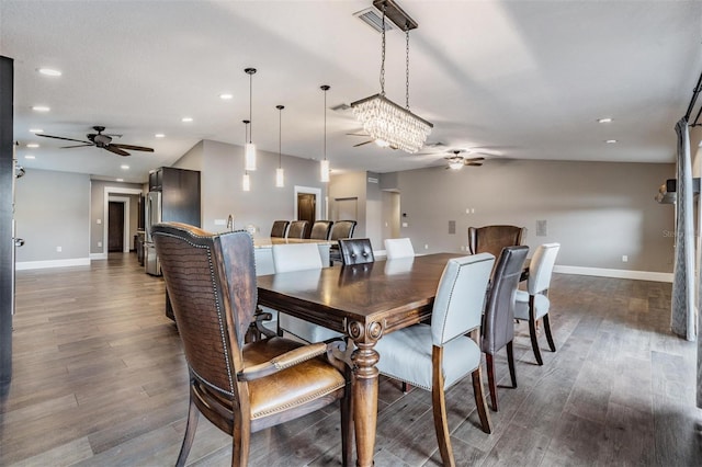 dining room featuring ceiling fan with notable chandelier and dark wood-type flooring