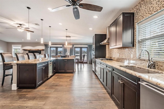 kitchen with sink, french doors, pendant lighting, a breakfast bar, and appliances with stainless steel finishes