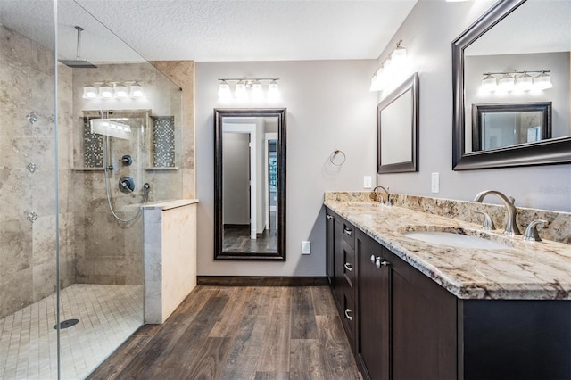 bathroom featuring an enclosed shower, vanity, a textured ceiling, and hardwood / wood-style floors