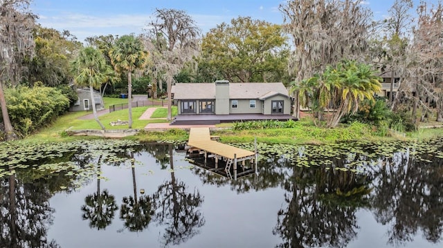 back of property featuring a lawn and a water view