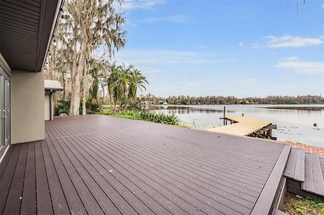 wooden deck featuring a boat dock and a water view