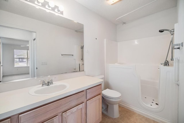 bathroom with toilet, vanity, and a textured ceiling