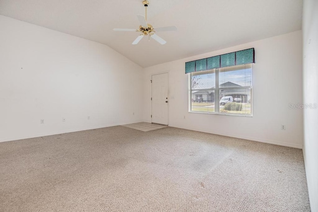 carpeted spare room with vaulted ceiling and ceiling fan