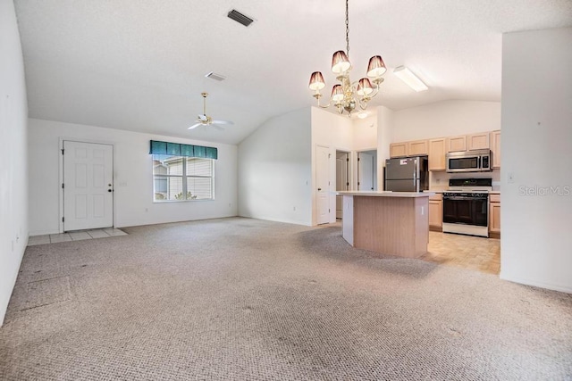 kitchen featuring a kitchen island, black fridge, gas range gas stove, hanging light fixtures, and ceiling fan with notable chandelier