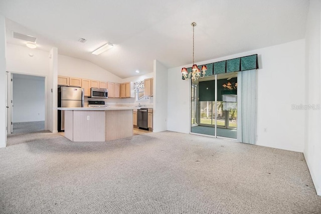 kitchen featuring appliances with stainless steel finishes, a center island, decorative light fixtures, light brown cabinetry, and vaulted ceiling