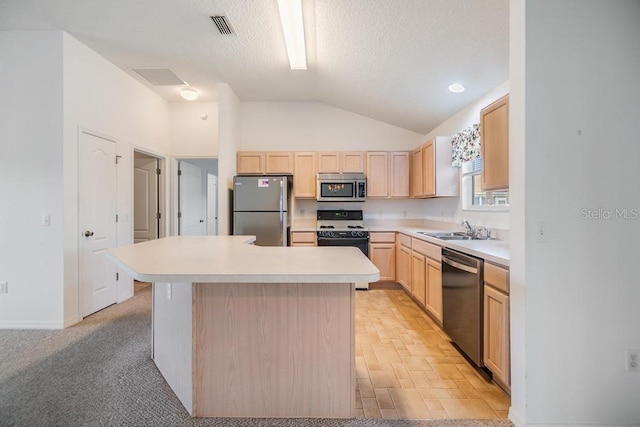 kitchen featuring a center island, sink, appliances with stainless steel finishes, light brown cabinets, and a textured ceiling