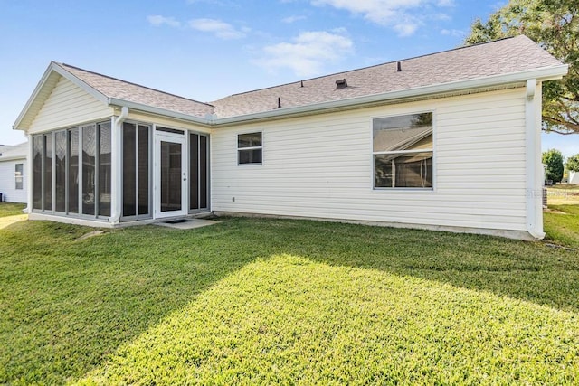 back of house with a lawn and a sunroom