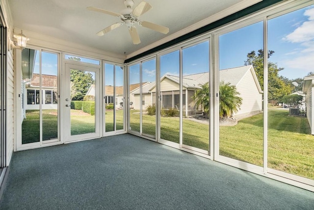 unfurnished sunroom featuring ceiling fan