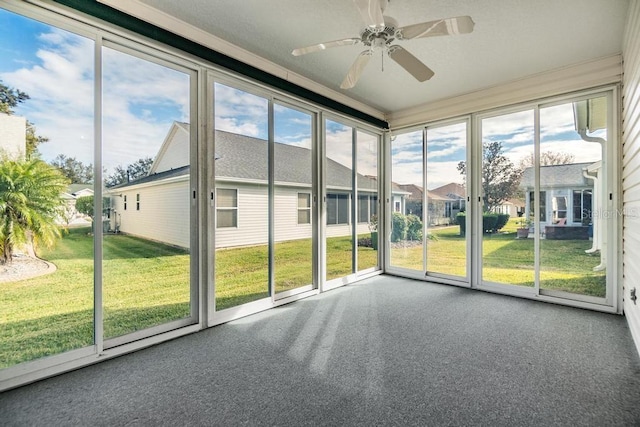 unfurnished sunroom featuring ceiling fan and a healthy amount of sunlight