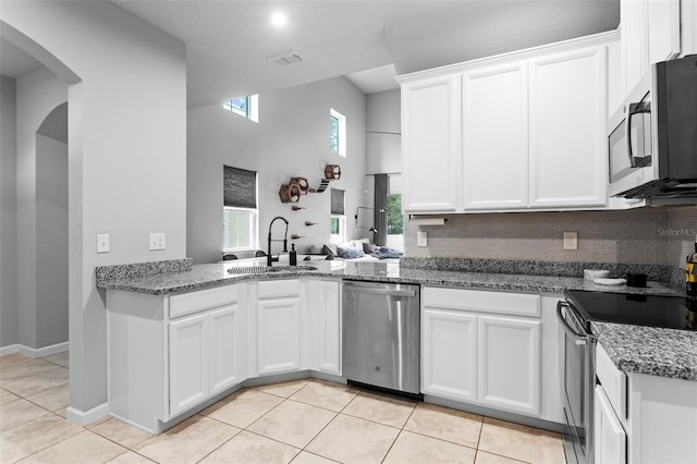 kitchen featuring stainless steel appliances, white cabinetry, sink, and light tile patterned floors