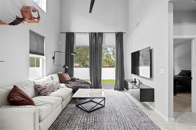 living room with a high ceiling and light tile patterned floors