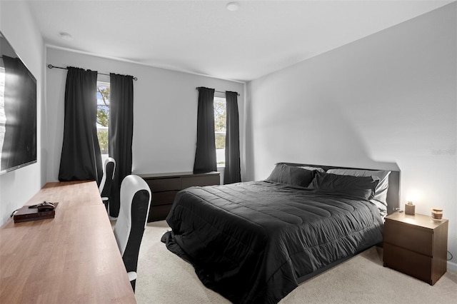 bedroom with multiple windows and light colored carpet