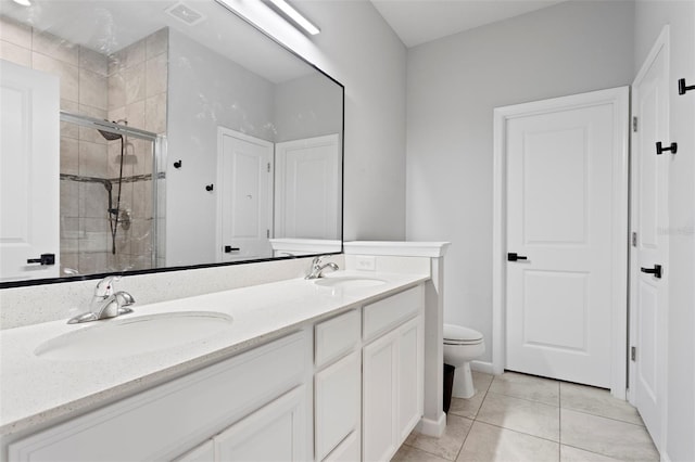 bathroom with vanity, tile patterned flooring, a shower with shower door, and toilet