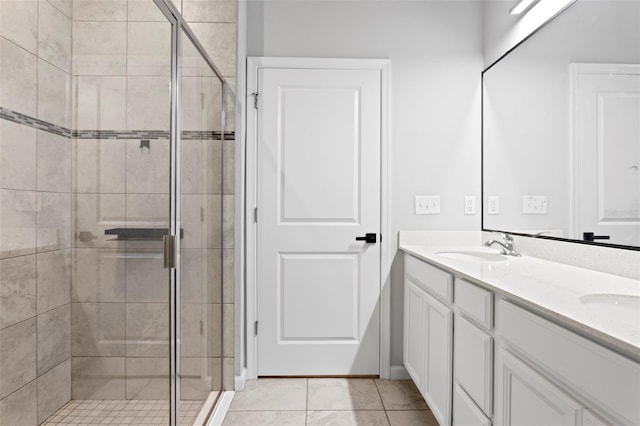 bathroom featuring a shower with door, tile patterned flooring, and vanity