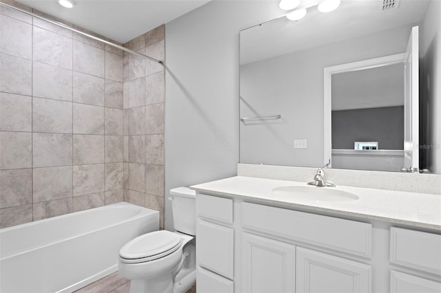 full bathroom featuring toilet, vanity, and tiled shower / bath