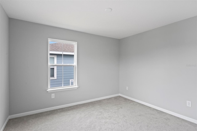 empty room with a wealth of natural light and carpet