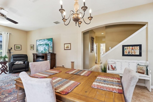 dining space with ceiling fan with notable chandelier