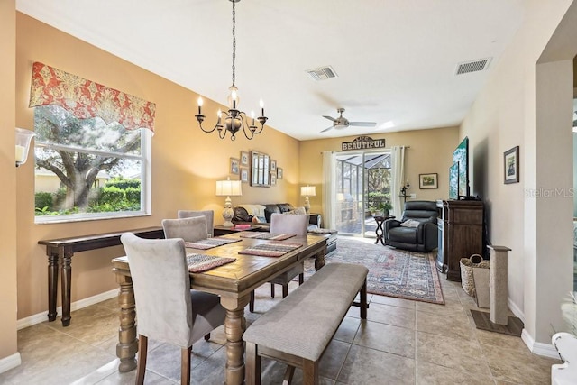 dining room with ceiling fan with notable chandelier and light tile patterned flooring