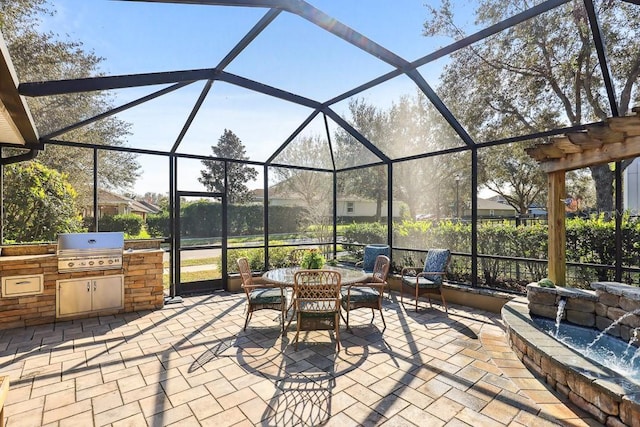 view of patio featuring area for grilling, a grill, glass enclosure, and pool water feature