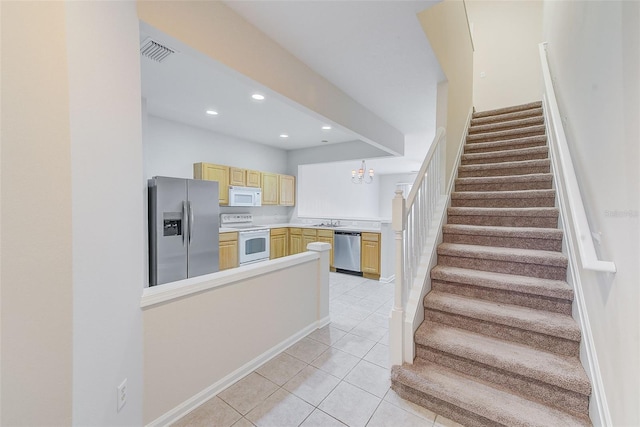 staircase with sink, tile patterned flooring, and a chandelier