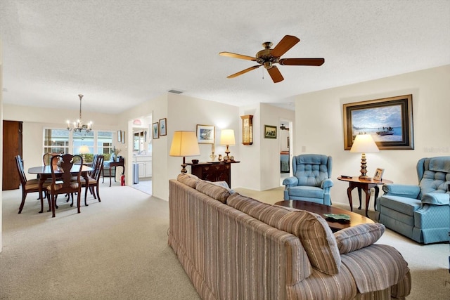 living room with ceiling fan with notable chandelier, light colored carpet, and a textured ceiling