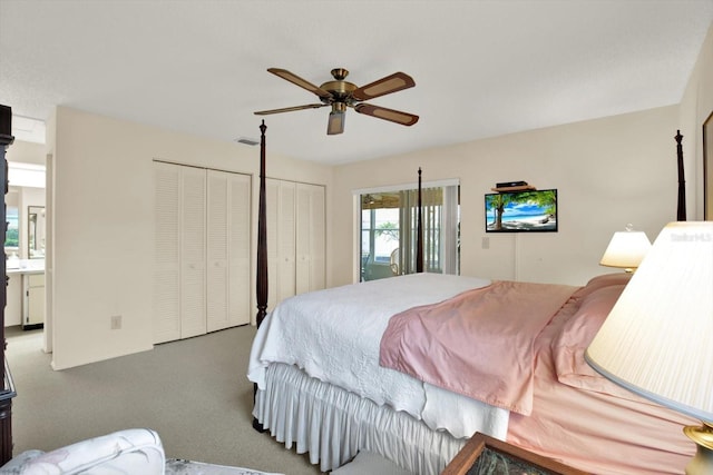 bedroom featuring ceiling fan, two closets, carpet, and ensuite bathroom