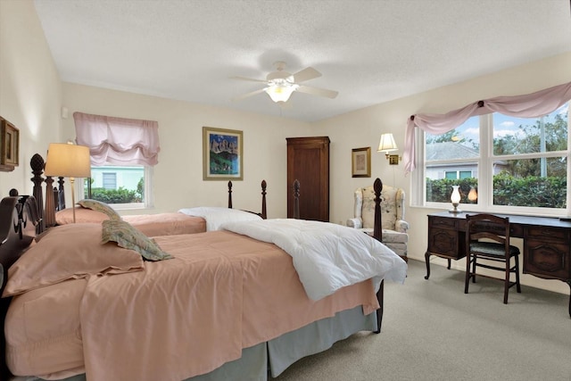 bedroom with ceiling fan, a textured ceiling, and light carpet