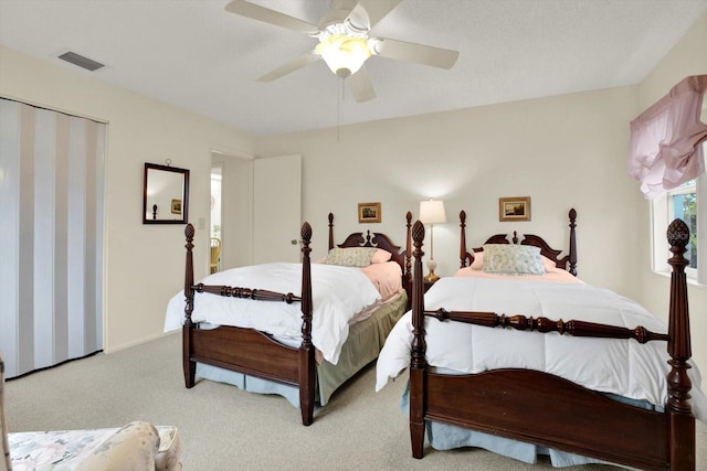 carpeted bedroom with ceiling fan and a closet