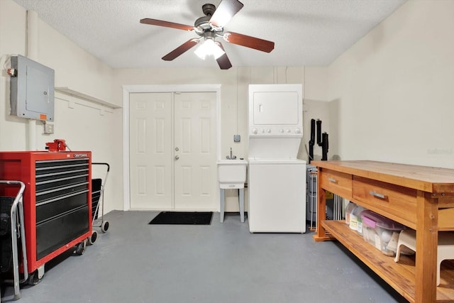 interior space featuring ceiling fan, stacked washing maching and dryer, and electric panel