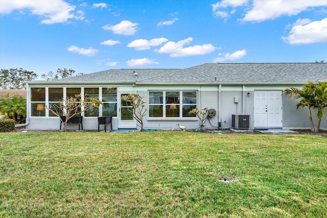 rear view of property with a lawn and cooling unit