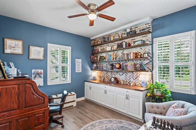 office featuring ceiling fan, a textured ceiling, light wood-type flooring, and plenty of natural light