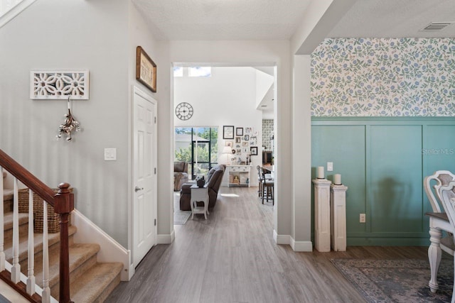 corridor featuring a textured ceiling and hardwood / wood-style floors