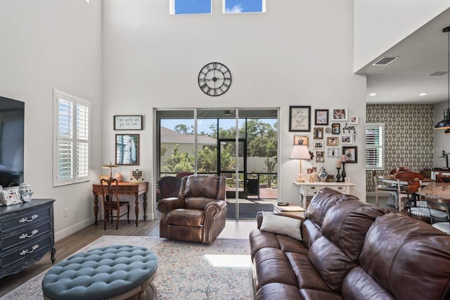 living room featuring a towering ceiling, hardwood / wood-style floors, and a wealth of natural light