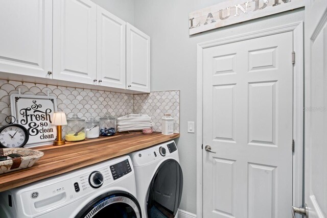 clothes washing area featuring cabinets and washing machine and clothes dryer