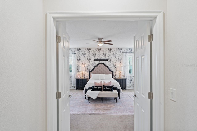 carpeted bedroom featuring a textured ceiling and ceiling fan