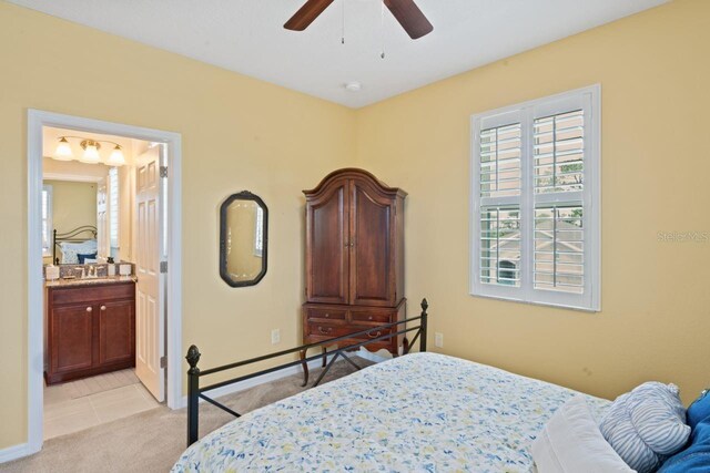 carpeted bedroom featuring sink, ceiling fan, and connected bathroom