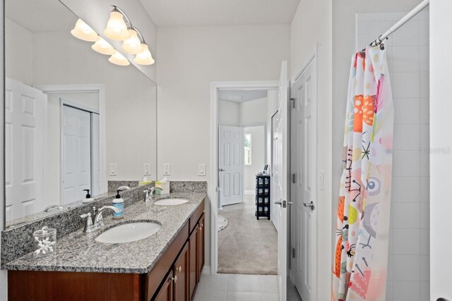 bathroom featuring walk in shower, tile patterned flooring, and vanity