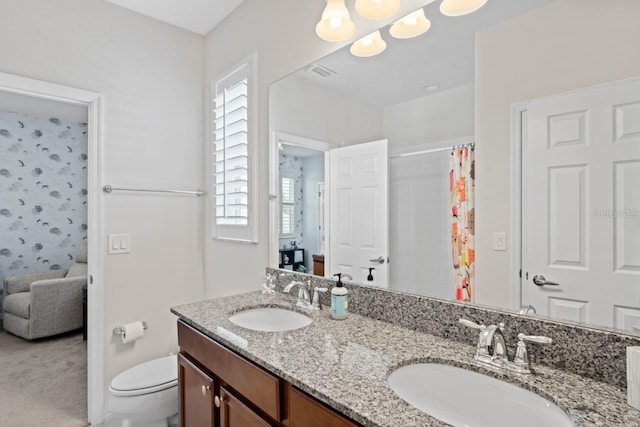 bathroom featuring a shower with shower curtain, vanity, and toilet